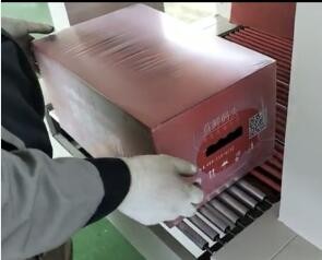 Shrink wrapping machine